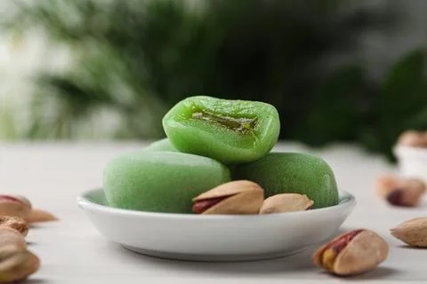 Delicious mochi and pistachios on white wooden table, closeup. Traditional Ja Stock Photos