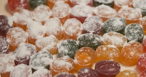 Delicious multi-colored caramels are scattered on table, white sugar powder Stock Footage 119095780