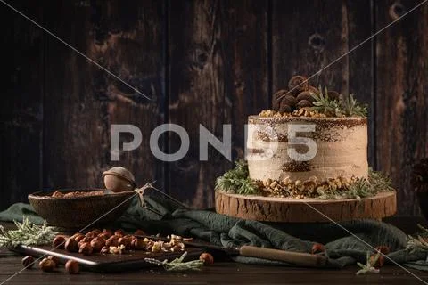 Delicious naked chocolate and hazelnuts cake on table rustic wood kitchen cou Stock Photos