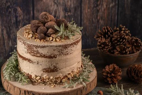 Delicious naked chocolate and hazelnuts cake on table rustic wood kitchen cou Stock Photos