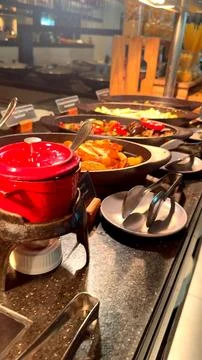 Delicious offerings at restaurant buffet include roasted vegetables in cast iron Stock Photos