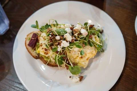 Delicious open faced egg breakfast sandwich with many toppings including ch.. Photos