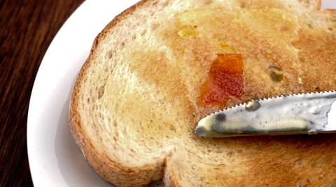 Delicious orange marmalade being spread on white toast in slow motion Stock Footage 46880322