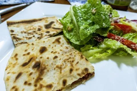 Delicious pan fried flat bread and accompanying colorful salads Stock Photos