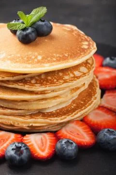 Delicious pancakes close up, with fresh blueberries, strawberries on a black  Stock Photos