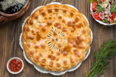 Delicious pie on the table next to the vegetables Stock Photos