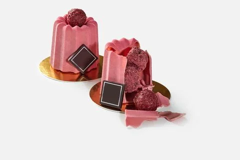 Delicious pink ruby chocolate modern pastry with raspberry filling revealing its Stock Photos