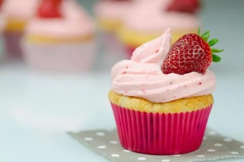 Delicious pink strawberry cupcake with a strawberry. Stock Photos