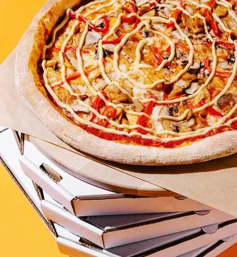 Delicious pizza topped with vegetables on a stack of boxes Stockfoto's