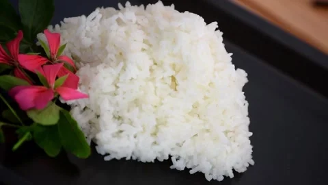 Delicious plain rice served with fresh flowers Stock Footage 320198802
