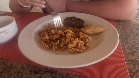 A Delicious Plate Featuring Twisted Pasta, Savory Meat, and Flaky Pastry on a 库存影片 330185161