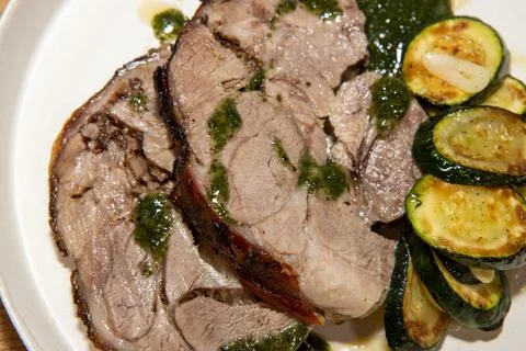 A delicious plate of Slow Roasted Lamb and Boulanger Potatoes on a wooden k.. Stock Photos