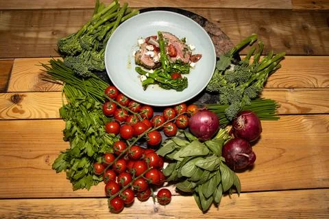 A delicious plate of Spring Lamb chops with spring vegetables on a wooden k.. Stock Photos
