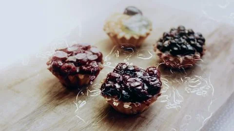 Delicious plating process view: arranging assorted tartlets in neat rows Stock Photos