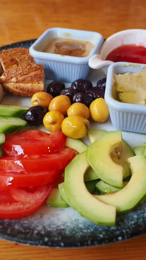 Delicious platter features sliced avocados, plum tomatoes, yellow cherries, and Stock Footage 336474760