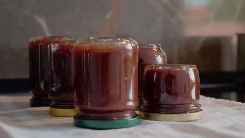 Delicious plum jam jars prepared in a cozy kitchen setting Stock Footage 320951402