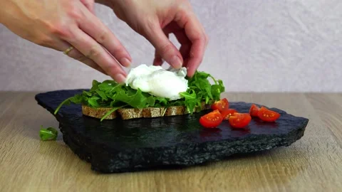 Delicious poached egg fresh slice of bread with ruccular and salt Stock Footage 206086727