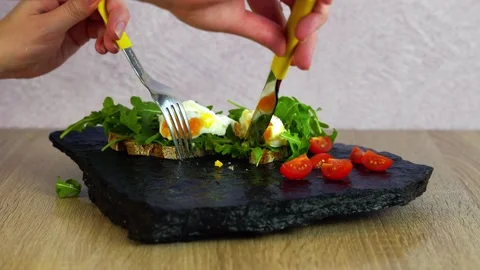 Delicious poached egg with runny egg yolk cut in the middle with a knife Stock Footage 206085134