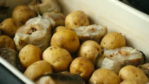 Delicious pollock fish with potatoes cooking in oven Stock Footage 337902146