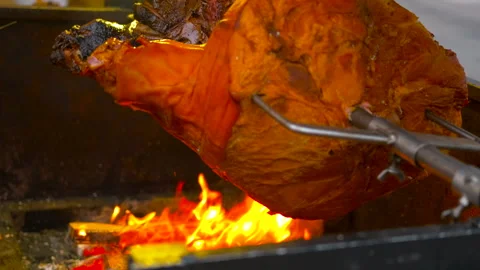 Delicious pork ham leg roasting on a spit over open fire 스톡 동영상 332693696