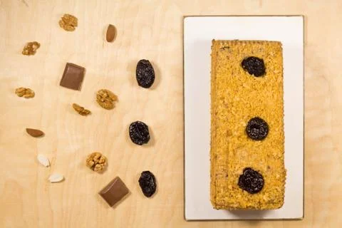 Delicious prune cake divided with nuts on wooden background Stock Photos