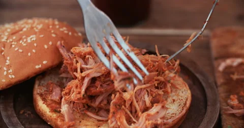 Delicious pulled pork being put on a burger bun Stock Footage