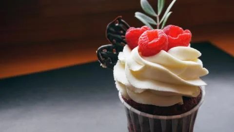 Delicious raspberry cupcakes on dark background Stock Photos