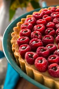 A delicious Raspberry Pie with chocolate served on a green plate over the t.. Stock Photos