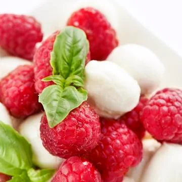 Delicious raspberry salad with mozarella and basil Stock Photos