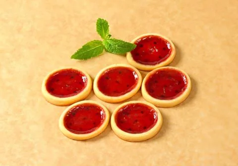 Delicious raspberry tartlets on a table Stock Photos