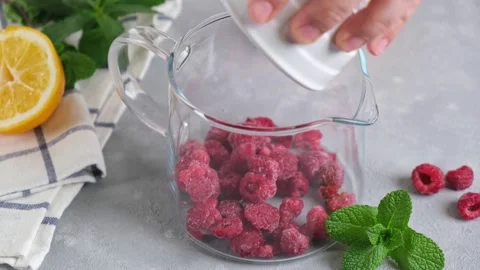 Delicious raspberry tea brewed in big glass teapot standing on a background Stock Footage 151162080