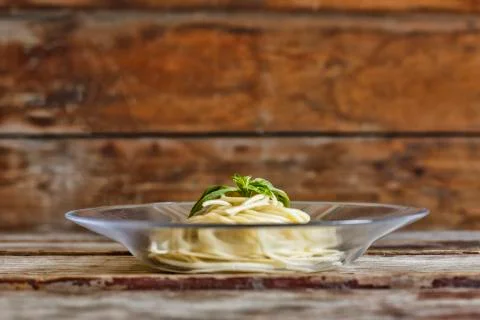 Delicious Ready-made spaghetti with basil leaf, in a transparent plate on a w 写真素材