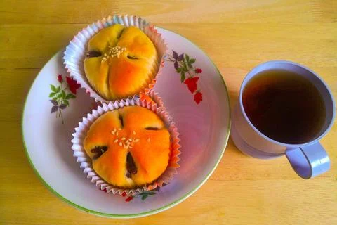 Delicious red bean flavored bread in a bowl and tea water 库存照片