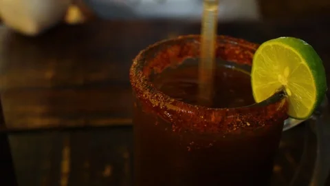 Delicious red michelada with Mexican beer and ice, served in a large jar Stock Footage