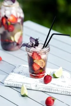 Delicious refreshing lemonade with basil, lime and strawberries Stock Photos