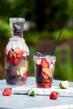 Delicious refreshing lemonade with basil, lime and strawberries Stock Photos
