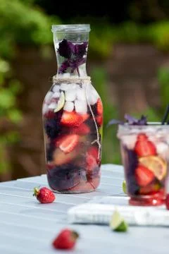 Delicious refreshing lemonade with basil, lime and strawberries Stock Photos