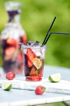 Delicious refreshing lemonade with basil, lime and strawberries Stock Photos