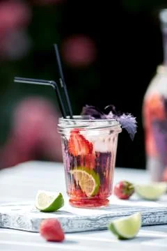 Delicious refreshing lemonade with basil, lime and strawberries Stock Photos