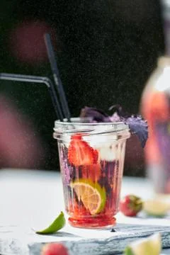 Delicious refreshing lemonade with basil, lime and strawberries Stock Photos