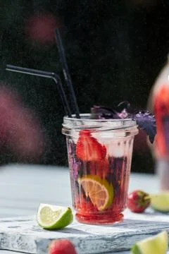 Delicious refreshing lemonade with basil, lime and strawberries Stock Photos