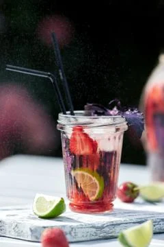 Delicious refreshing lemonade with basil, lime and strawberries Stock Photos