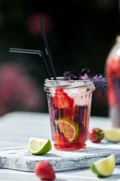 Delicious refreshing lemonade with basil, lime and strawberries Stock Photos