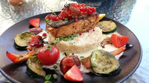 Delicious risotto with baked grilled salmon steak with berries and vegetables Stock Footage 159608619