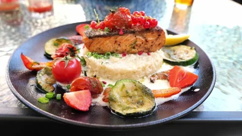 Delicious risotto with baked grilled salmon steak with berries and vegetables Stock Footage 159608681