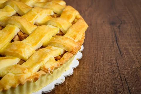 Delicious round apple pie resting on wooden table Stock Photos