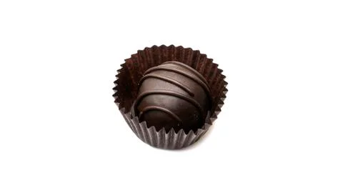 Delicious, round, chocolate candy in wrapper with nuts on a white background. Stock Photos