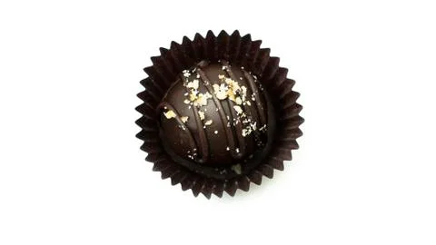 Delicious, round, chocolate candy in wrapper with nuts on a white background. Stock Photos