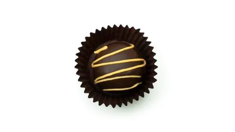 Delicious, round, chocolate candy in wrapper with nuts on a white background. Stock Photos