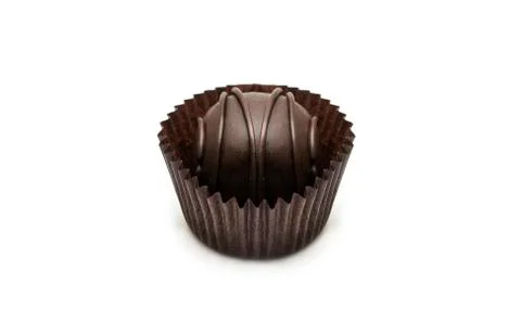 Delicious, round, chocolate candy in wrapper with nuts on a white background. Stock Photos